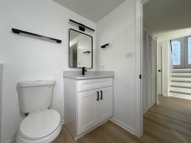 bathroom with hardwood / wood-style flooring, vanity, and toilet