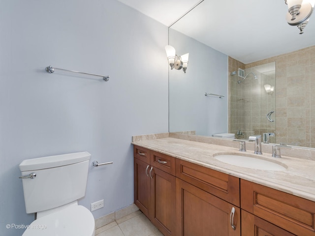 bathroom featuring a tile shower, tile patterned flooring, vanity, and toilet