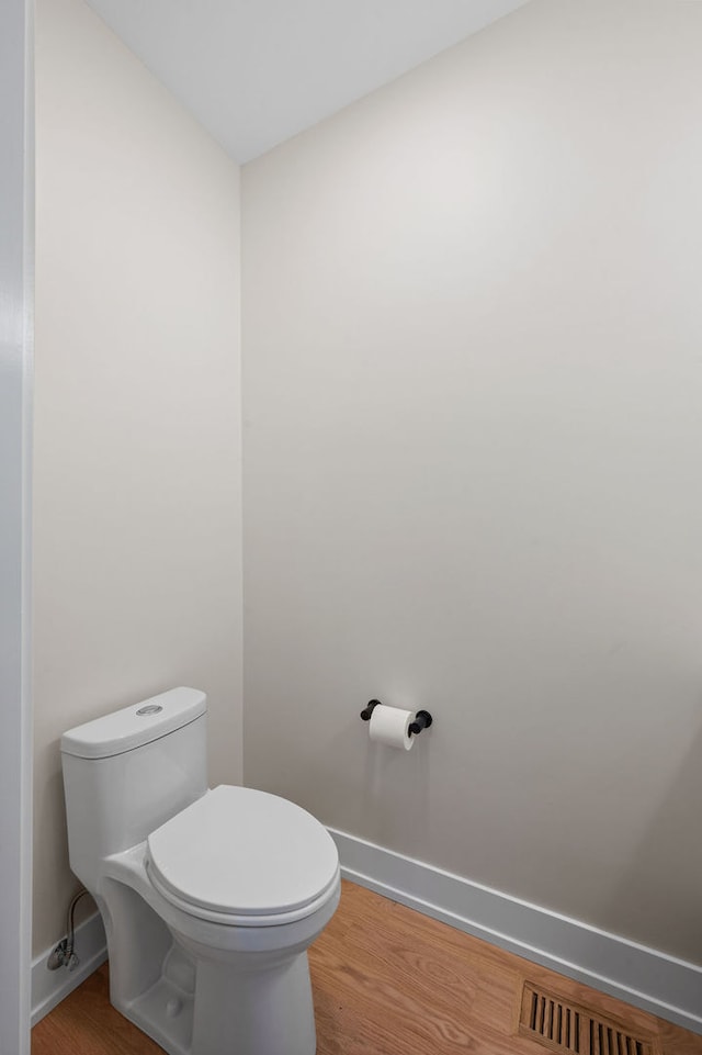 bathroom with toilet and hardwood / wood-style flooring