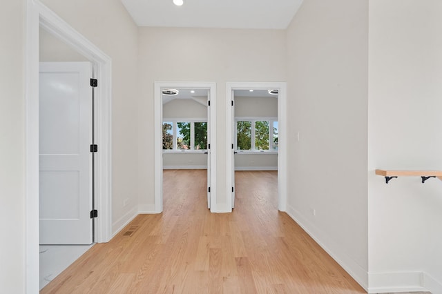 hallway featuring light hardwood / wood-style floors and vaulted ceiling