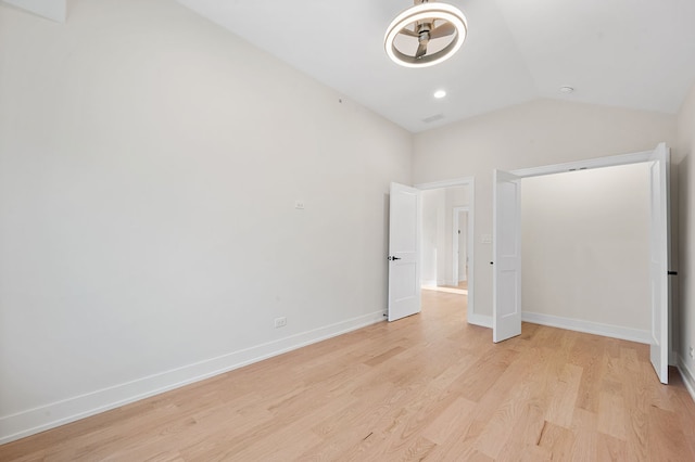 unfurnished bedroom featuring light hardwood / wood-style floors and lofted ceiling