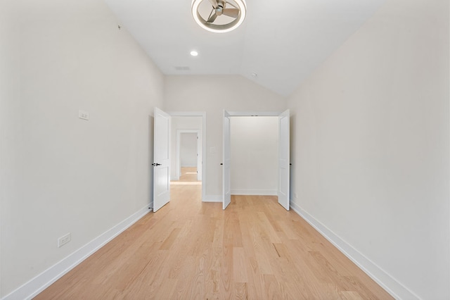 unfurnished bedroom with light wood-type flooring and vaulted ceiling