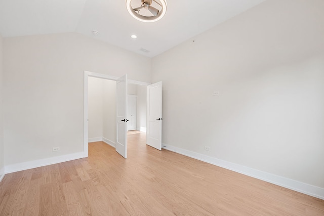 unfurnished room with light hardwood / wood-style flooring and lofted ceiling