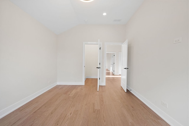 unfurnished bedroom featuring vaulted ceiling and light hardwood / wood-style flooring