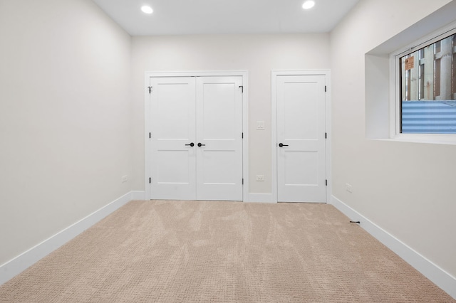 unfurnished bedroom featuring light carpet