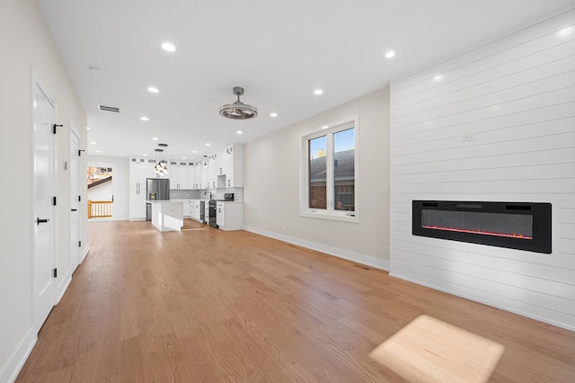 unfurnished living room featuring a fireplace and light hardwood / wood-style flooring