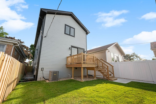 rear view of house featuring a wooden deck, a lawn, and central air condition unit