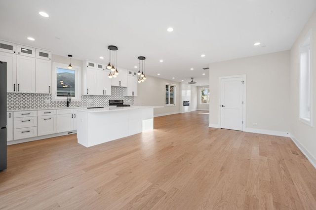 kitchen featuring white cabinetry, pendant lighting, and light wood-type flooring