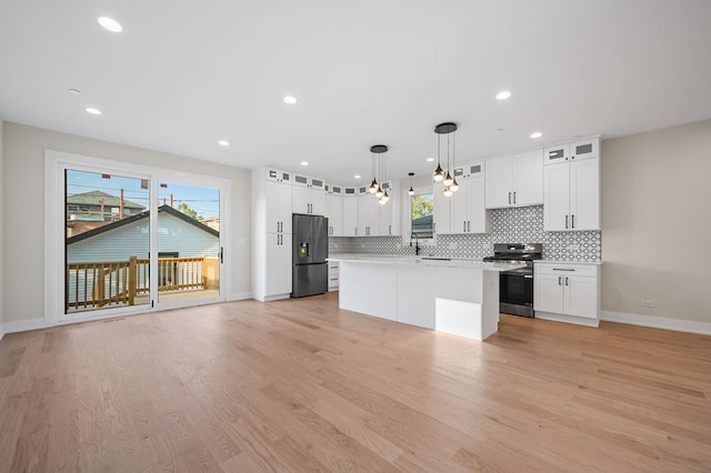 kitchen featuring white cabinets, decorative light fixtures, stainless steel appliances, and a healthy amount of sunlight