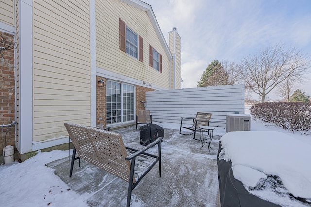 snow covered patio featuring cooling unit