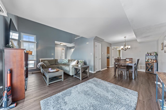 living room with dark hardwood / wood-style flooring and a notable chandelier