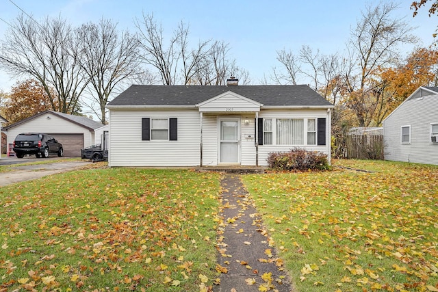 view of front of house featuring an outbuilding, a front yard, and a garage