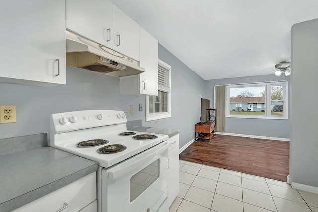 kitchen featuring light wood-type flooring, white range with electric stovetop, ceiling fan, vaulted ceiling, and white cabinetry