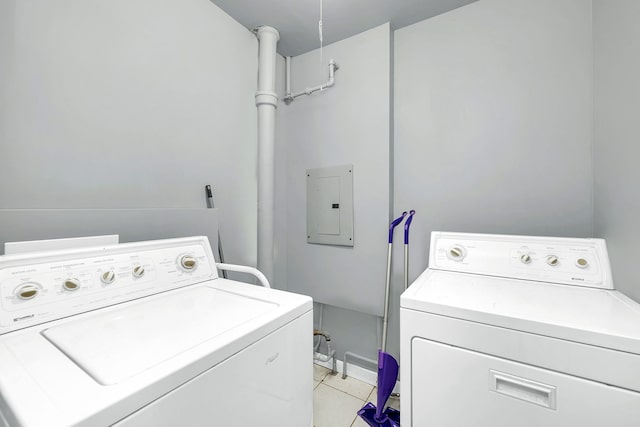 clothes washing area featuring washer and dryer, light tile patterned floors, and electric panel