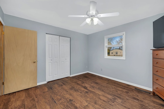 unfurnished bedroom featuring a closet, dark hardwood / wood-style floors, and ceiling fan