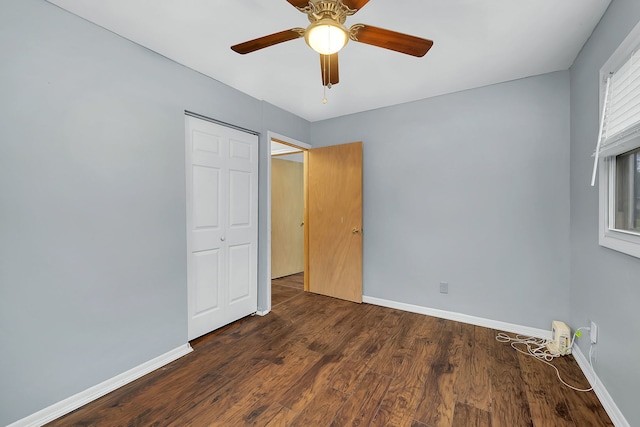 unfurnished bedroom with a closet, ceiling fan, and dark hardwood / wood-style flooring