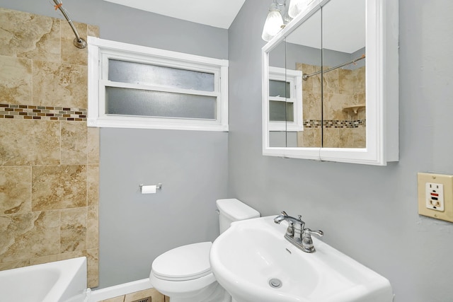 full bathroom with tile patterned floors, toilet, tiled shower / bath, and sink