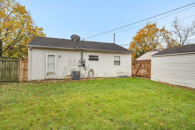 rear view of property with a lawn and central AC