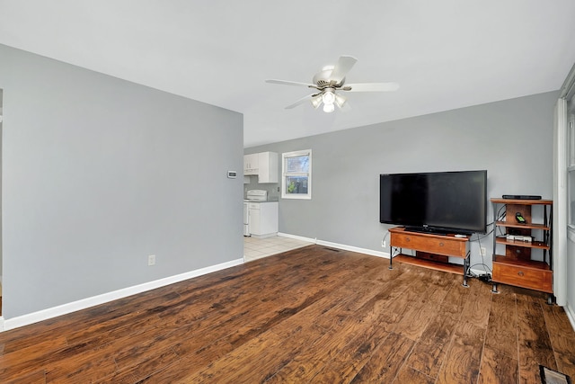 living room featuring ceiling fan, light wood-type flooring, and washing machine and clothes dryer