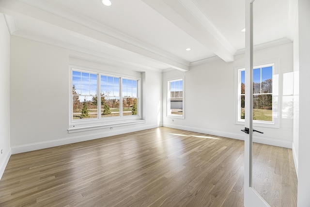 empty room featuring hardwood / wood-style flooring, beam ceiling, and ornamental molding