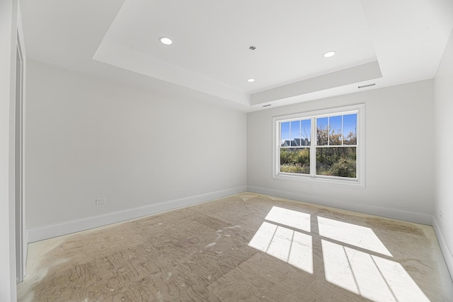 unfurnished room featuring a raised ceiling