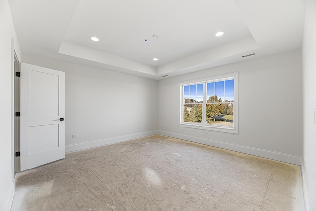 unfurnished room featuring a tray ceiling