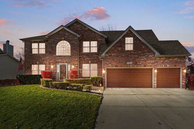 view of front of home featuring a lawn and a garage