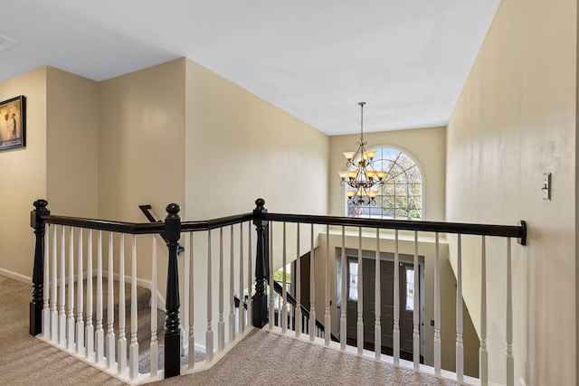 stairway with carpet floors and a chandelier