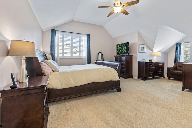 bedroom featuring multiple windows, ceiling fan, light carpet, and vaulted ceiling