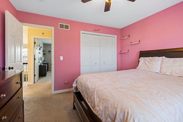 bedroom with ceiling fan, light carpet, and a closet