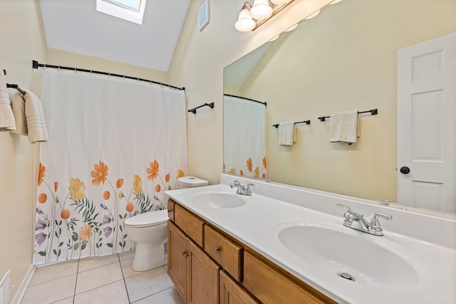 bathroom with tile patterned floors, lofted ceiling with skylight, vanity, and toilet