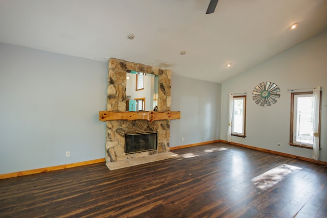 unfurnished living room featuring wood-type flooring, a stone fireplace, and lofted ceiling