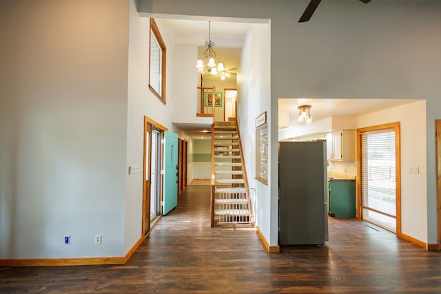 corridor with dark wood-type flooring and a notable chandelier