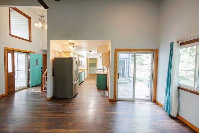 kitchen with dark hardwood / wood-style flooring, stainless steel fridge, plenty of natural light, and a high ceiling