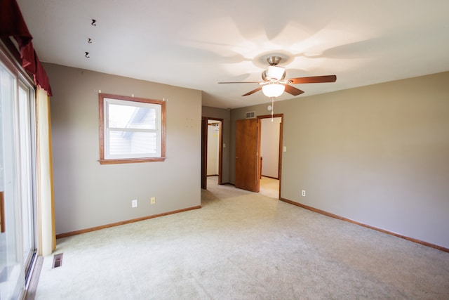 unfurnished bedroom featuring light colored carpet and ceiling fan