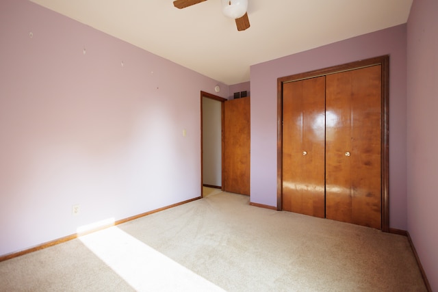 unfurnished bedroom featuring carpet, ceiling fan, and a closet