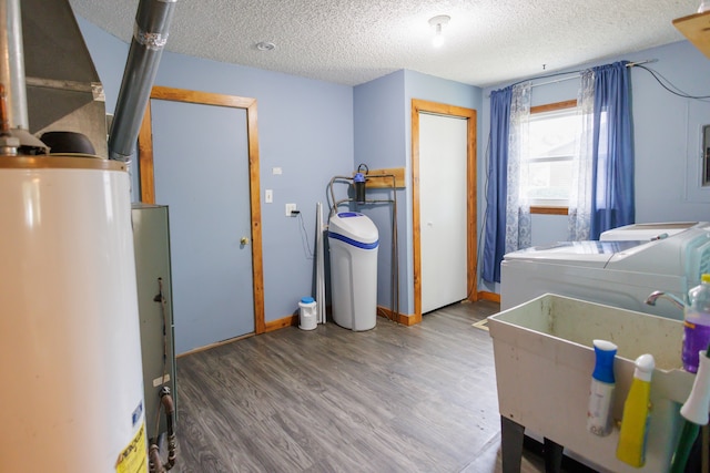 clothes washing area featuring sink, hardwood / wood-style flooring, washer and dryer, a textured ceiling, and water heater