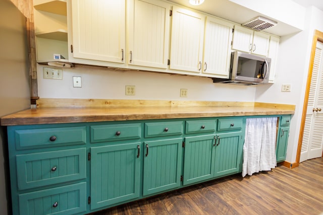 kitchen with butcher block countertops, white cabinetry, and dark hardwood / wood-style flooring