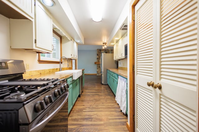 kitchen with white cabinets, dark hardwood / wood-style floors, sink, and stainless steel appliances