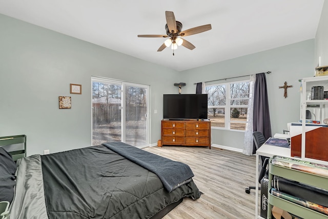 bedroom featuring baseboards, access to outside, multiple windows, and light wood-style floors