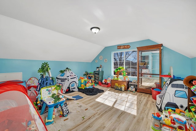 recreation room featuring vaulted ceiling and wood finished floors