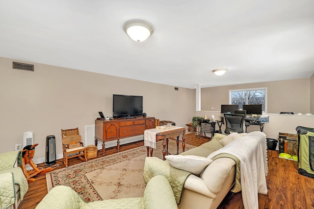 living area with wood finished floors and visible vents