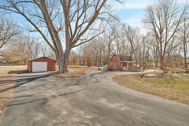 view of street featuring driveway and a barn