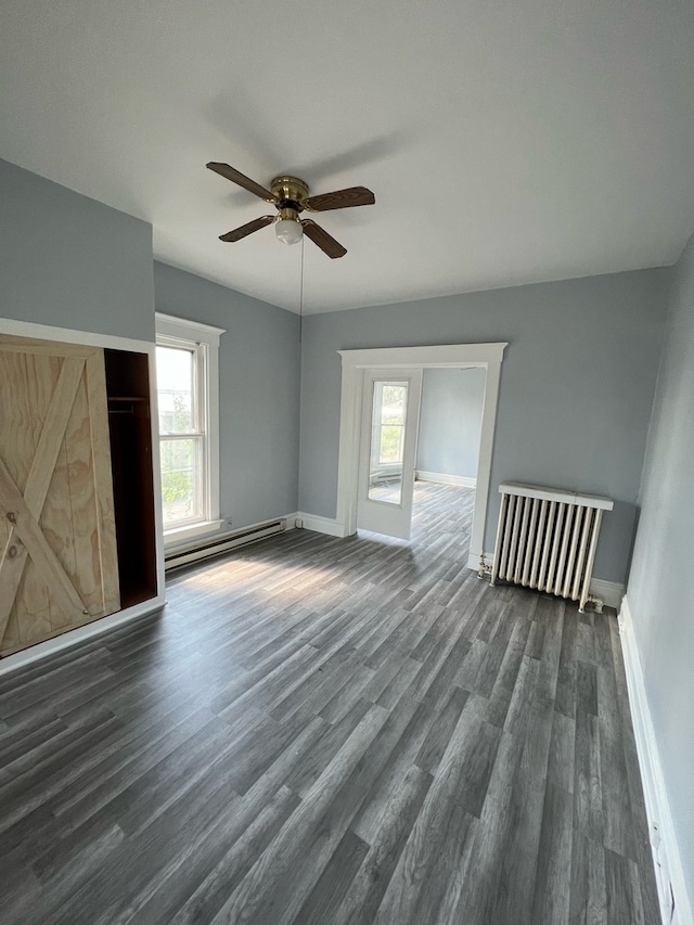 interior space featuring radiator heating unit, dark hardwood / wood-style flooring, plenty of natural light, and a baseboard heating unit