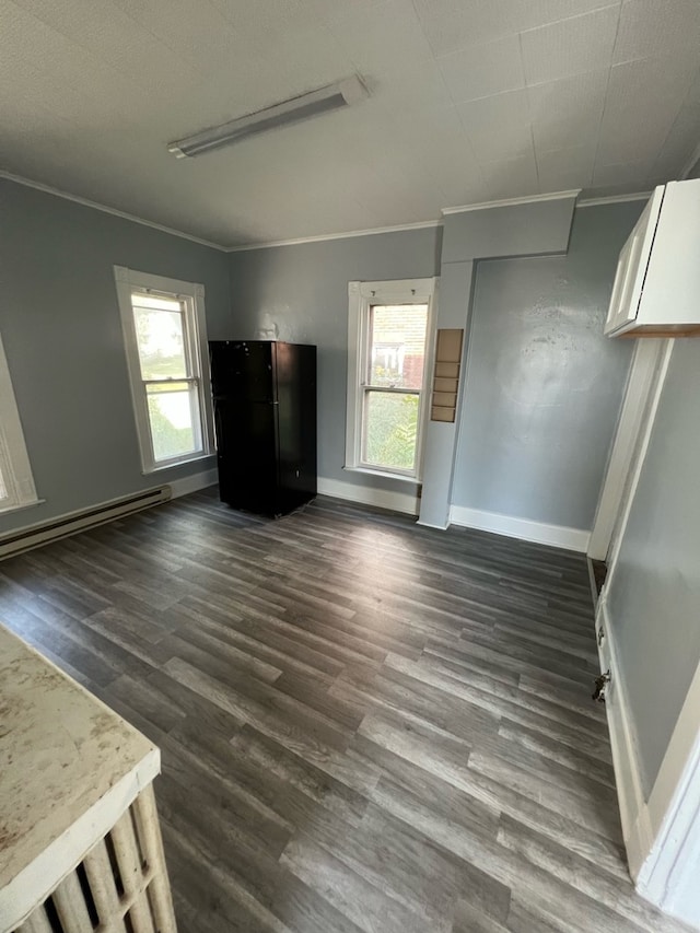 living room with dark hardwood / wood-style floors, baseboard heating, crown molding, and a wealth of natural light