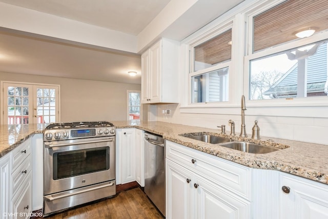 kitchen with french doors, sink, light stone counters, white cabinetry, and stainless steel appliances