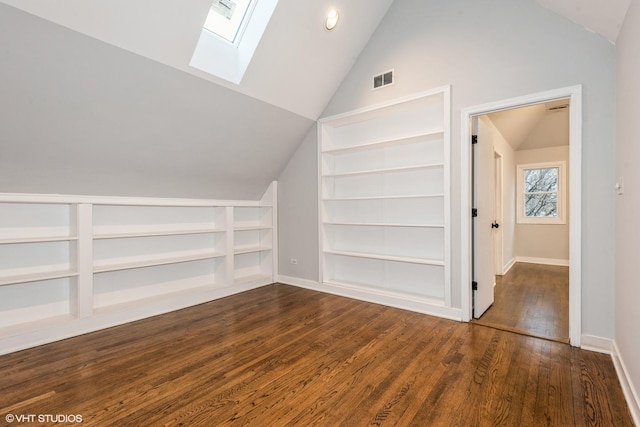 bonus room featuring built in shelves, lofted ceiling with skylight, and dark hardwood / wood-style floors