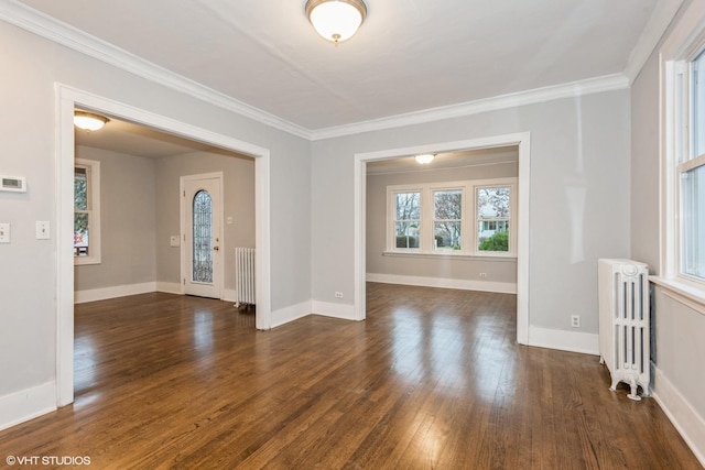 unfurnished room with crown molding, radiator heating unit, and dark wood-type flooring