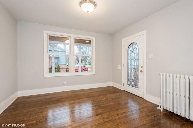 entrance foyer with radiator heating unit and dark hardwood / wood-style floors