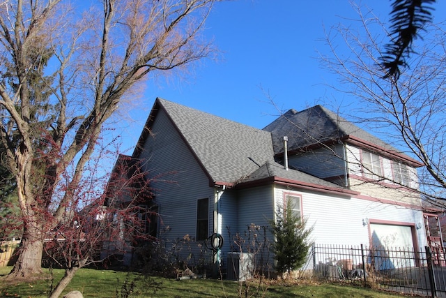 view of property exterior with a garage and a yard